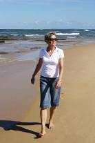 woman walks alond the beach enjoying her exercise regime